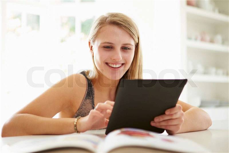 Teenage Girl Studying Using Digital Tablet At Home, stock photo