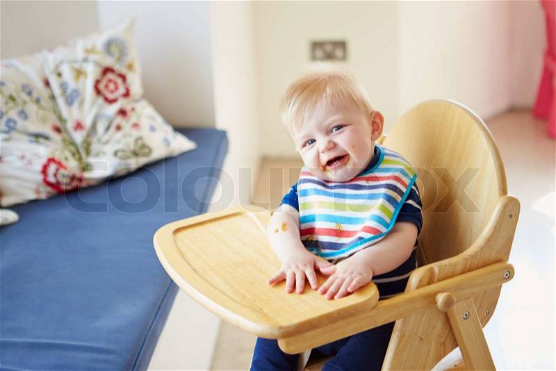 Baby Boy Sitting In High Chair, stock photo