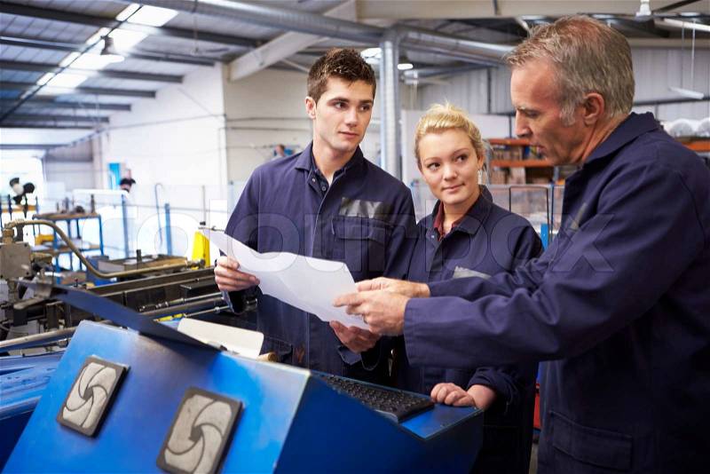 Engineer Teaching Apprentices To Use Tube Bending Machine, stock photo