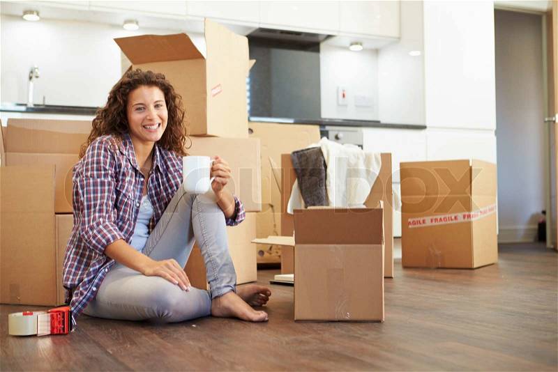 Woman Moving Into New Home And Unpacking Boxes, stock photo