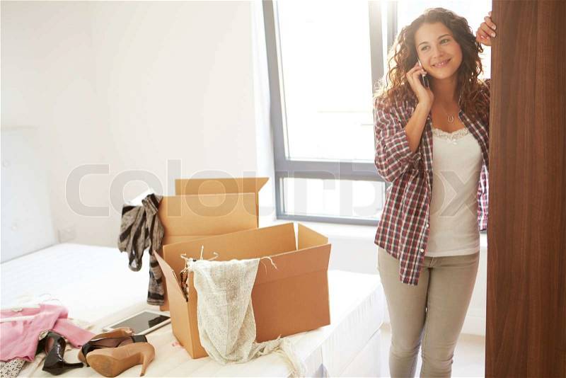 Woman Moving Into New Home Talking On Mobile Phone, stock photo