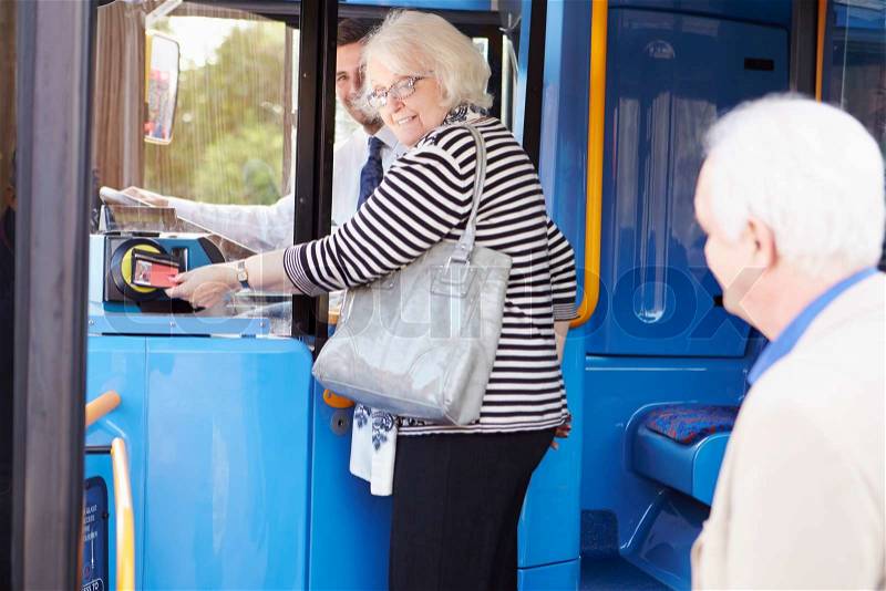 Senior Couple Boarding Bus And Using Pass, stock photo