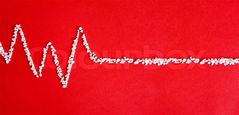 Pulse rate made from salt on red background, stock photo