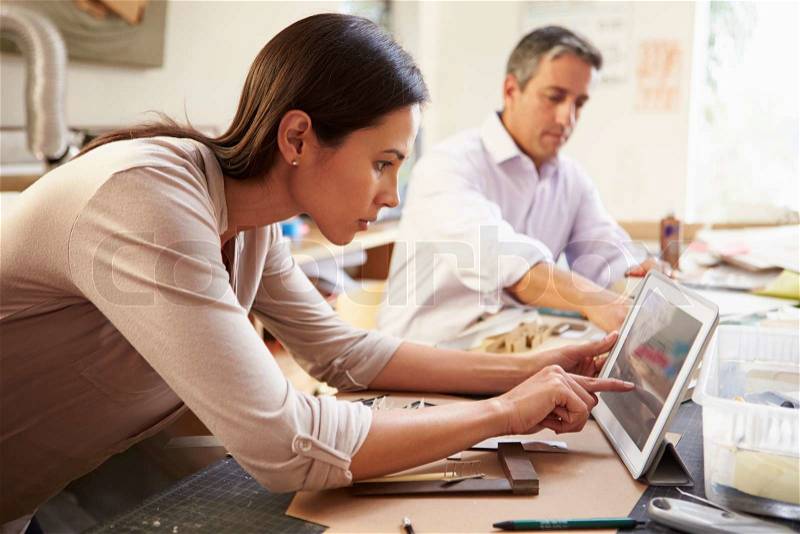 Two Architects Making Models In Office Using Digital Tablet, stock photo