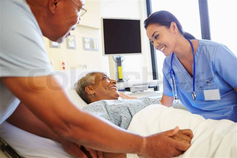 Nurse Talking To Senior Couple In Hospital Room, stock photo