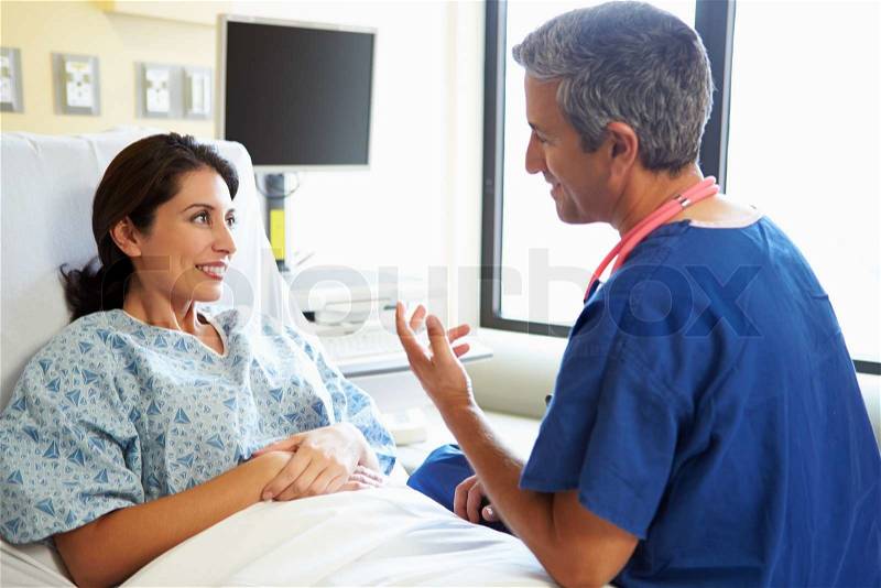 Male Nurse Talking With Female Patient In Hospital Room, stock photo