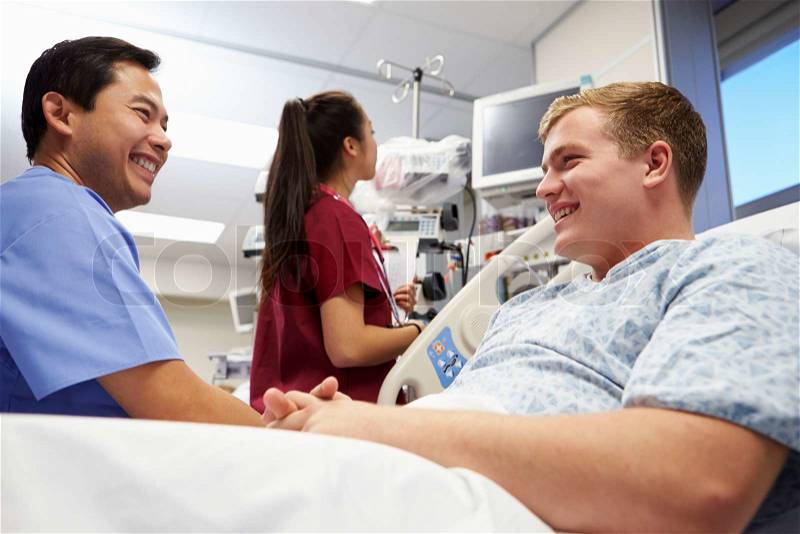 Male Patient Talking To Medical Staff In Emergency Room, stock photo
