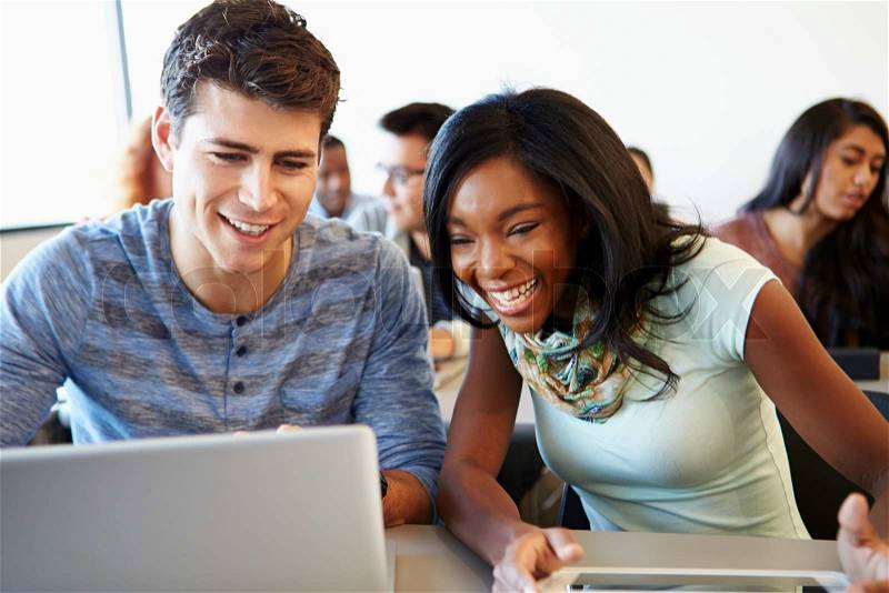 University Students Using Digital Tablet And Laptop In Class, stock photo