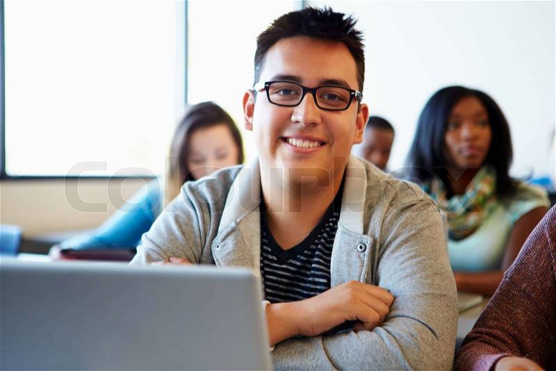 Male University Student Using Laptop In Classroom, stock photo