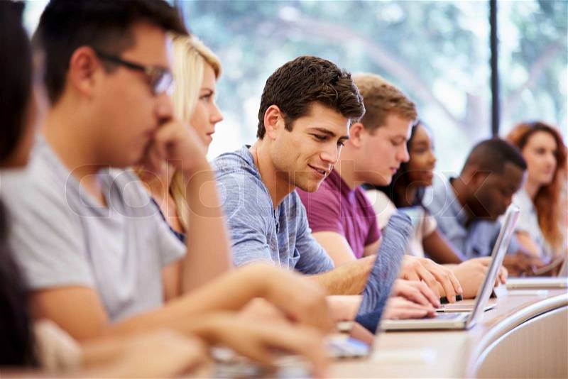 Class Of University Students Using Laptops In Lecture, stock photo