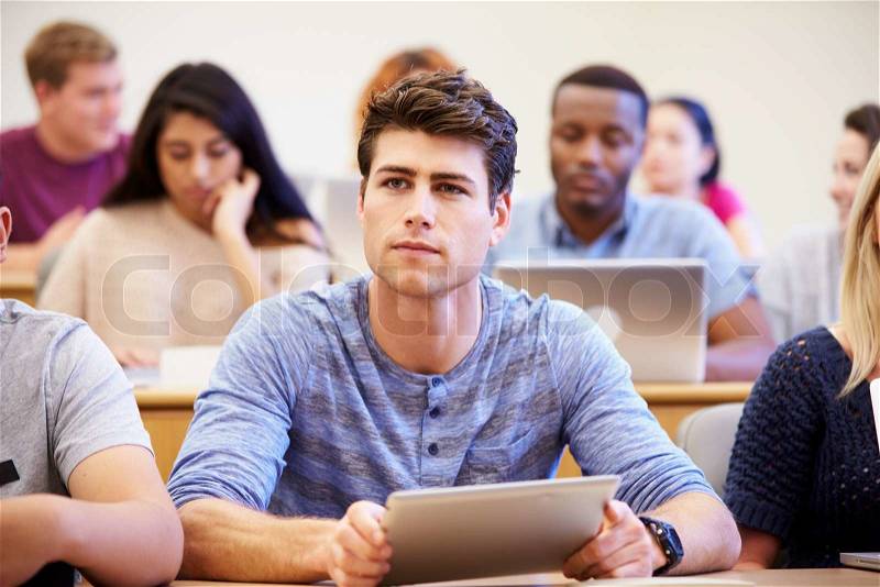 Male University Student Using Digital Tablet In Lecture, stock photo