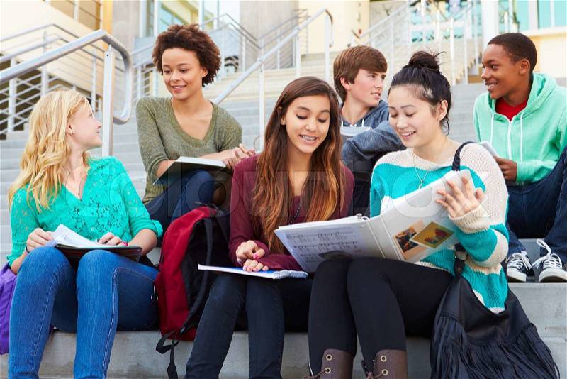 Group Of High School Students Sitting Outside Building, stock photo