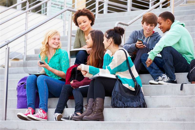 Group Of High School Students Sitting Outside Building, stock photo