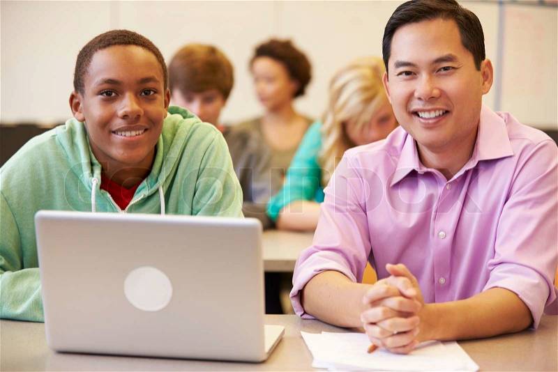 High School Student With Teacher In Class Using Laptop, stock photo