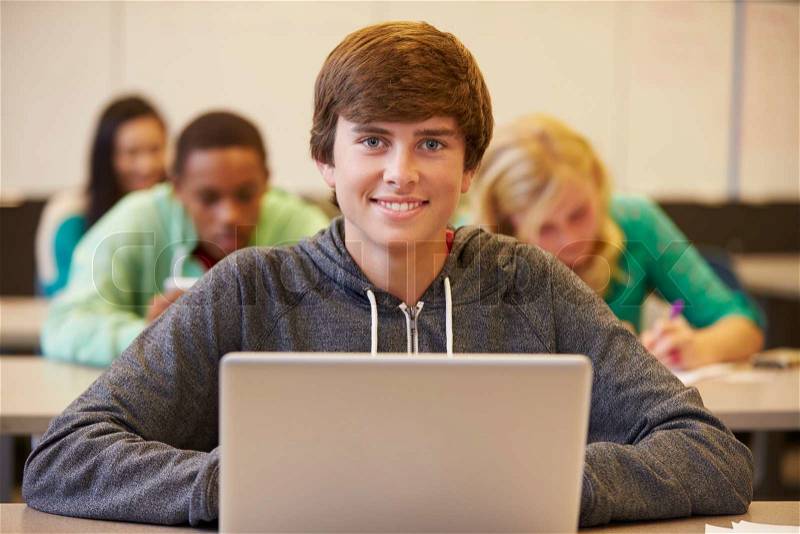 High School Student At Desk In Class Using Digital Tablet, stock photo