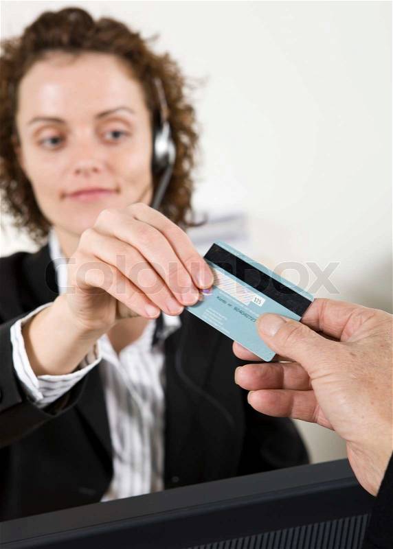 A female receptionist getting a patient\'s ID card, stock photo