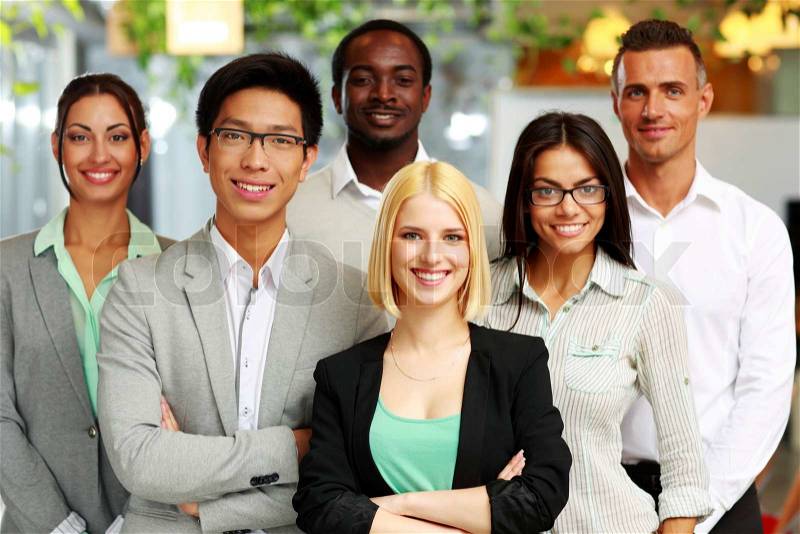 Happy group of co-workers standing in office, stock photo