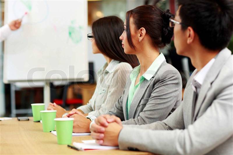 Business people sitting around a table during a meeting in office, stock photo