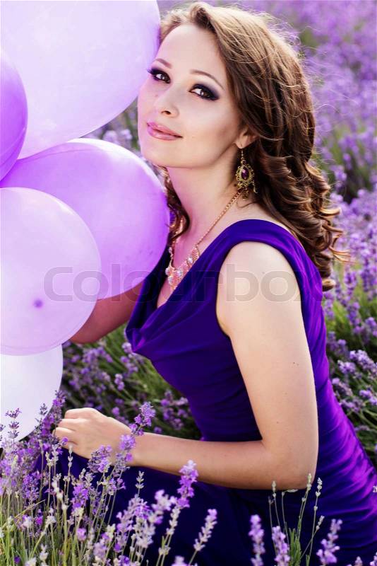 Adorable girl with purple balloons in lavender field. Summer freedom enjoy concept, stock photo