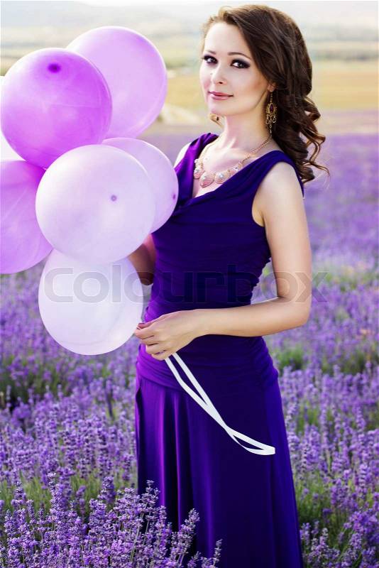 Adorable pretty girl with purple balloons in lavender field. Summer freedom enjoy concept, stock photo