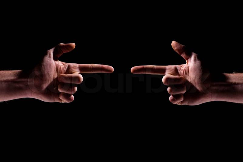 Two hands pointing at each other over black background, stock photo