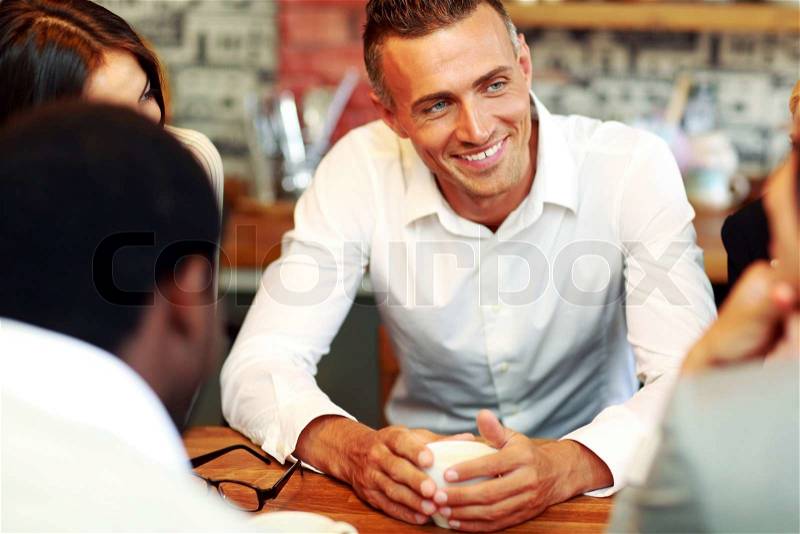 Happy business people having meeting around table in office, stock photo