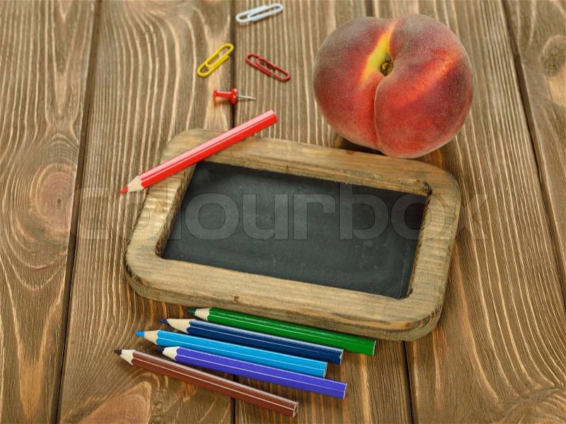 Writing board and pencils on brown background, stock photo