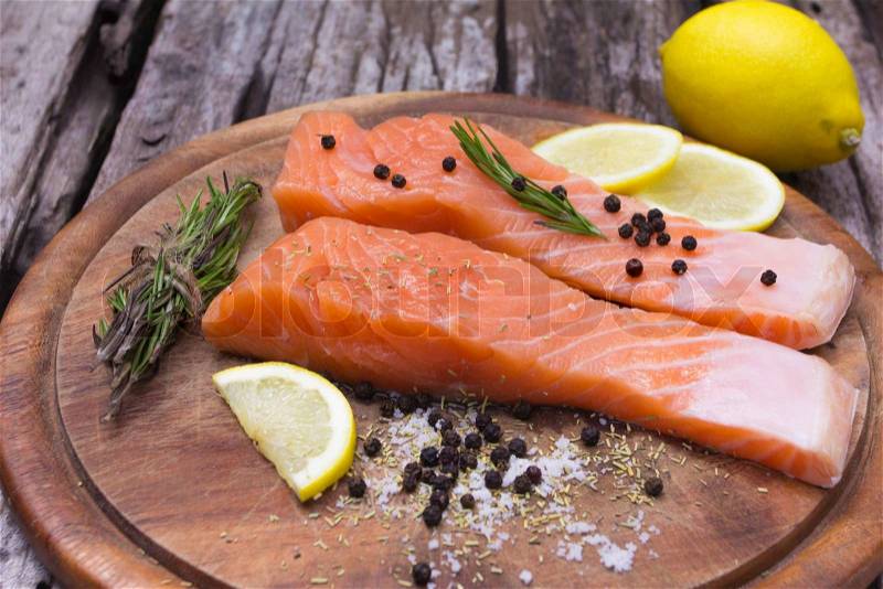 Fresh salmon with spices on old wood, stock photo