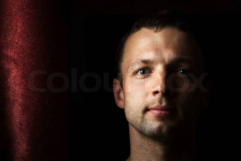 Young Caucasian man close up portrait with curtain, stock photo
