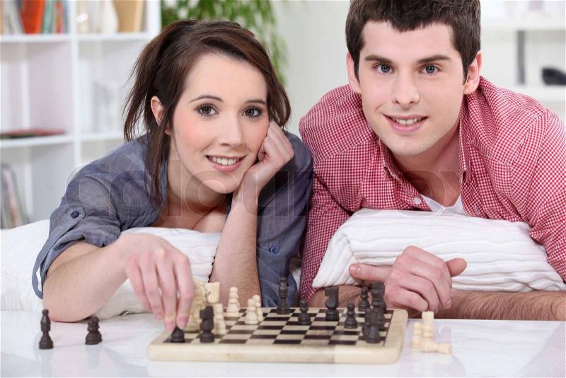 Young man and young woman playing chess, stock photo