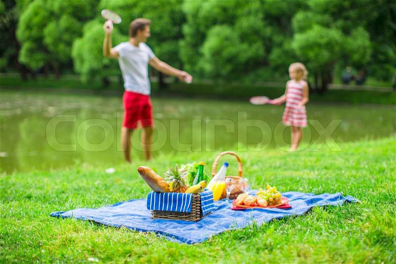 Happy cute family picnicking in the park, stock photo