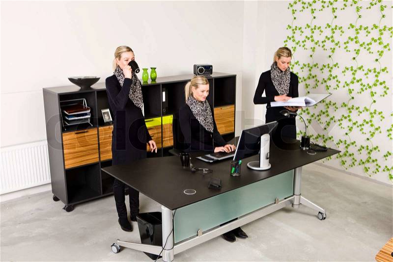 A female office worker multitasking at work, stock photo
