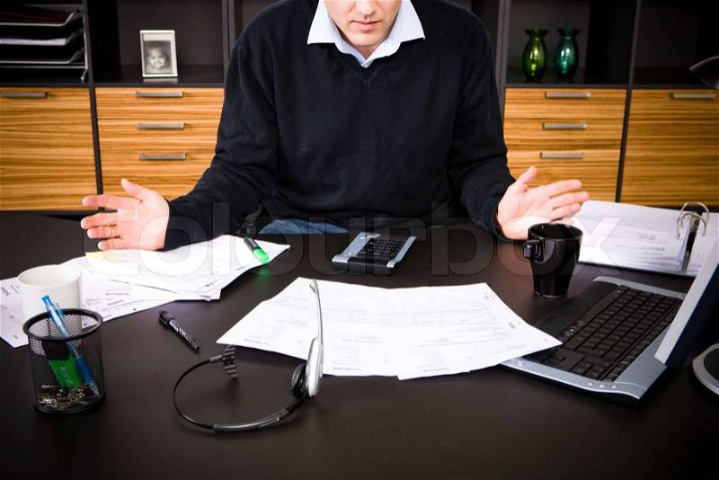 A businessman with loads of paper work, stock photo