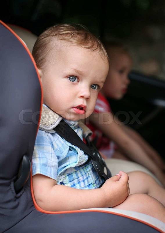 Cute toddler boy in car seat in the summer, stock photo