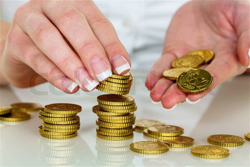 A woman stacks coins. save money for the future, stock photo