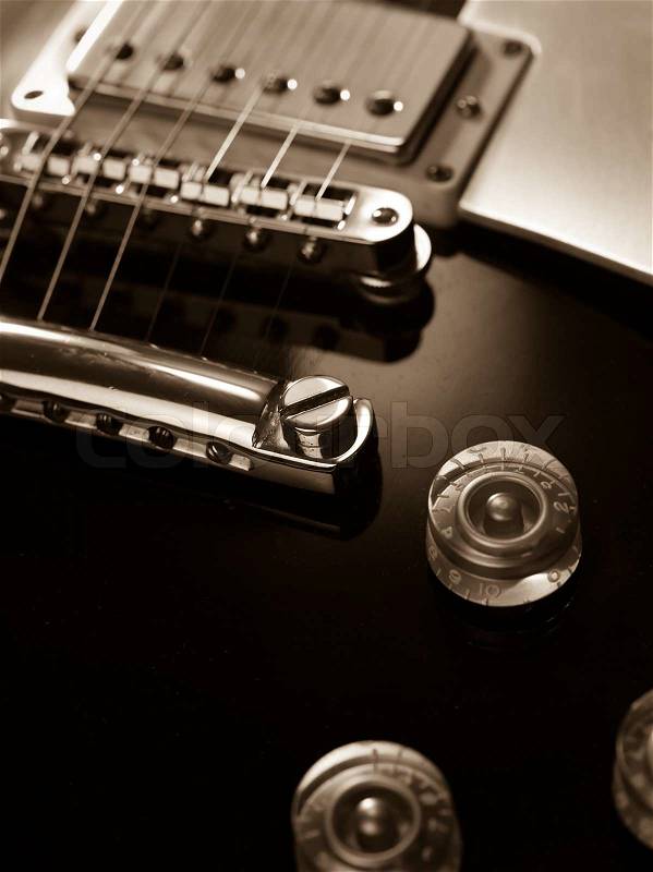 Macro abstract photo of the pickup, bridge and strings of an electric guitar. Shallow depth of field with focus across the middle, stock photo