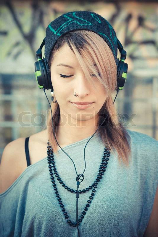 Young beautiful model woman listening music in the city, stock photo