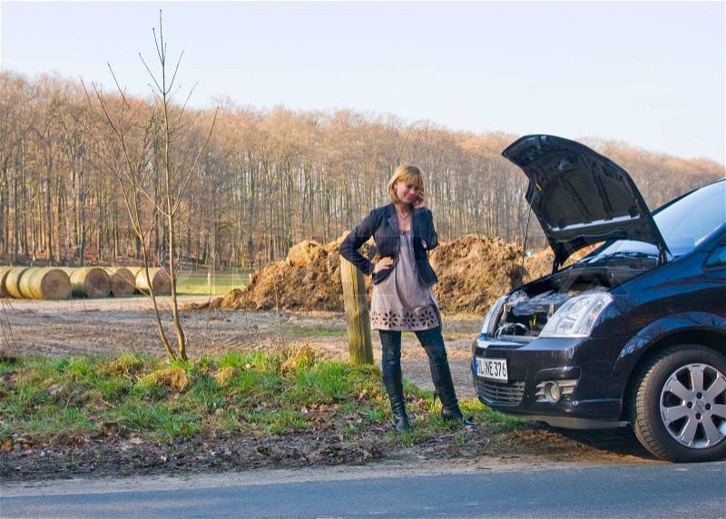 A woman with car problem calls for help, stock photo