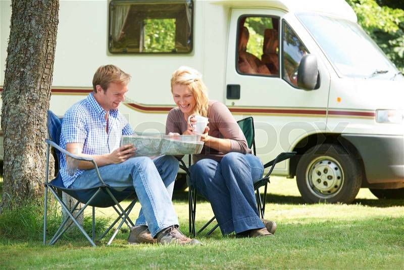 Couple Relaxing Outside Motor Home On Vacation, stock photo