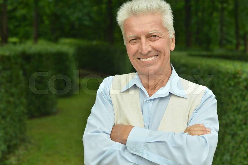 Portrait of happy elderly man in summer park, stock photo