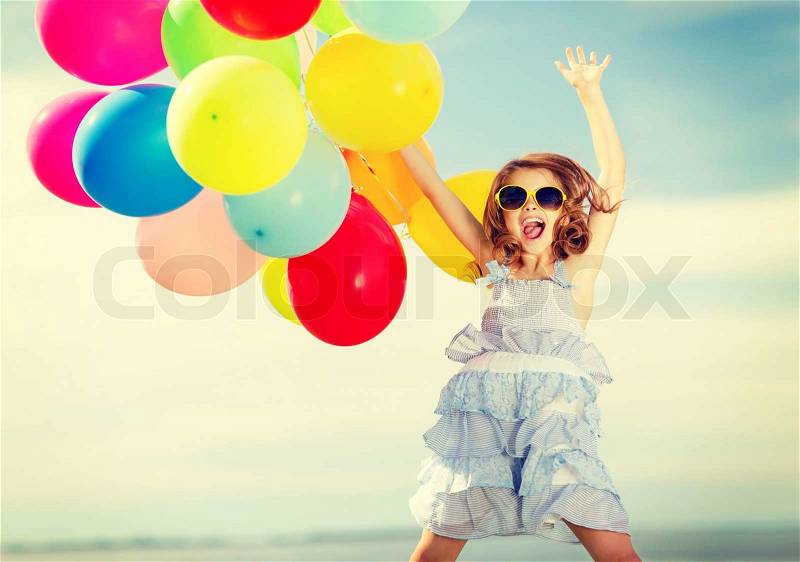 Summer holidays, celebration, children and people concept - happy jumping girl with colorful balloons outdoors, stock photo