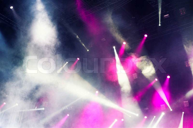 Spotlights illuminating the stage at a concert with fog , stock photo