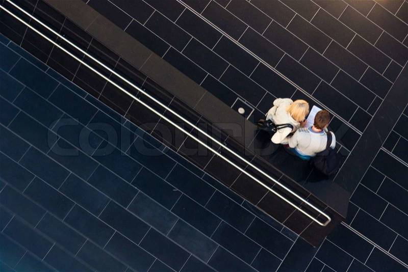Couple reviewing the decision on child adoption on the tiled hallway, stock photo