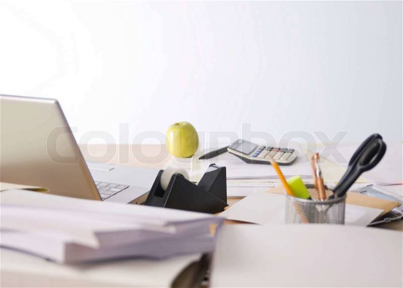 Desk with laptop, apple and documents, stock photo