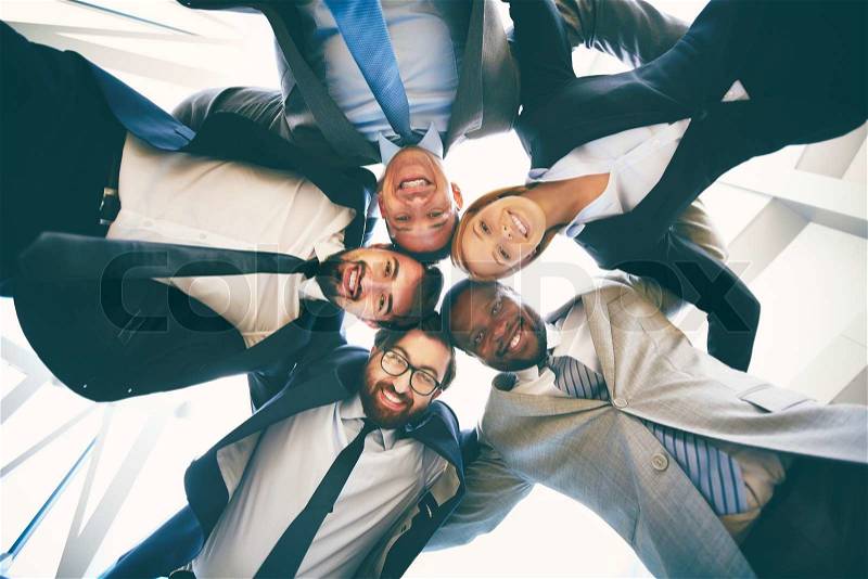 Group of happy businesspeople in suits standing head to head, stock photo