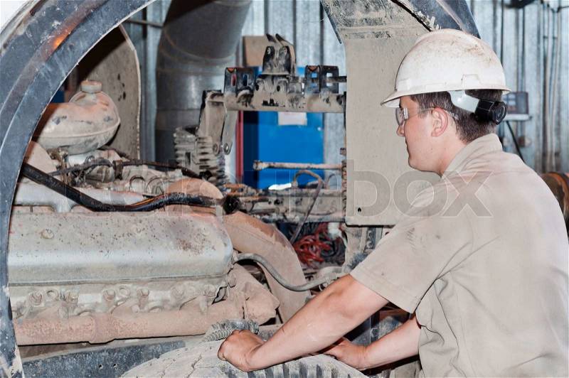Motor mechanic diagnosing automobile car engine before maintenance at repair service station, stock photo