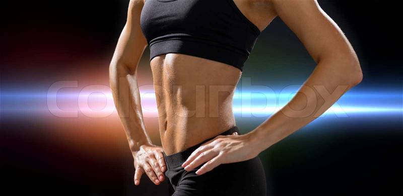 Fitness and diet concept - close up of beautiful athletic female abs in sportswear, stock photo