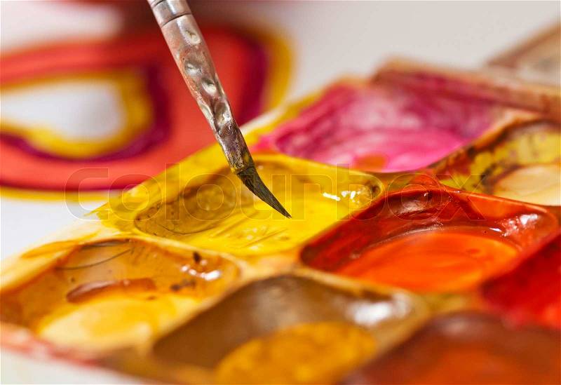 Water colour paints and brush for drawing by paints in hands of the child, stock photo