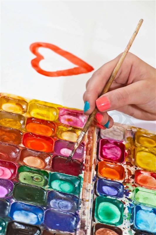 Water colour paints and brush for drawing by paints in hands of the child, stock photo