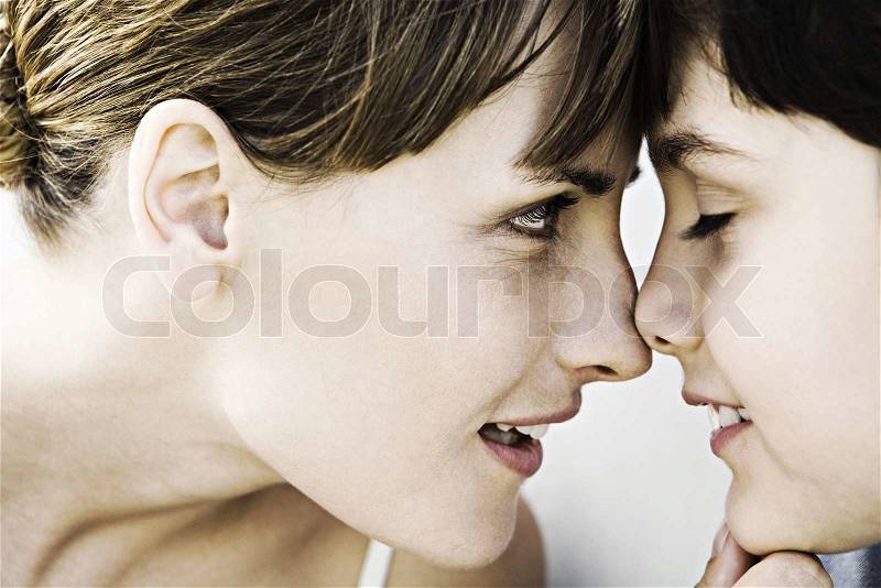 Mother and son touching noses, boy's eyes closed, side view, stock photo